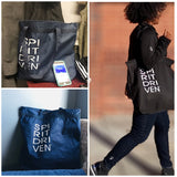 Picture with one navy and one black nylon tote bag with the SPIRITDRIVEN logo.  Also a  woman is pictured with the bag on her shoulder.
